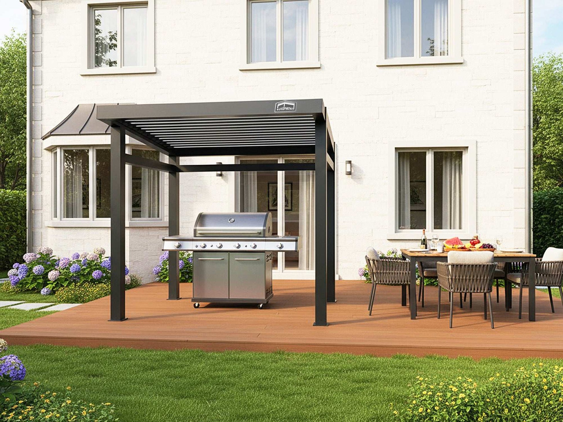 A black louvered pergola covering a large grill and an outdoor dining area on a wooden deck next to a white house.